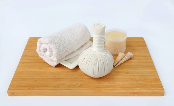 Spa herbal compressing ball with towels and Salt Scrub, Spa concept on bamboo board against white background