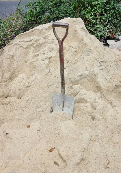 Строительная лопата застряла в песке, сломалась во время работы — стоковое фото