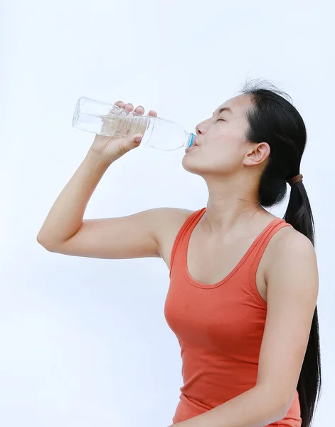 Femme saine buvant de l'eau après l'entraînement, Fitness Girl in Workout Concept sur fond blanc . — Photo