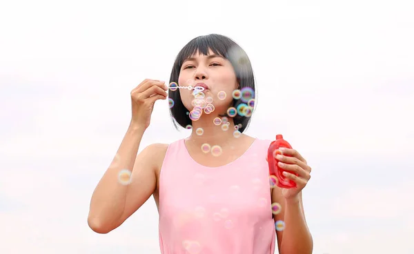 Fiatal ázsiai nő játék buborék, fehér háttér. — Stock Fotó