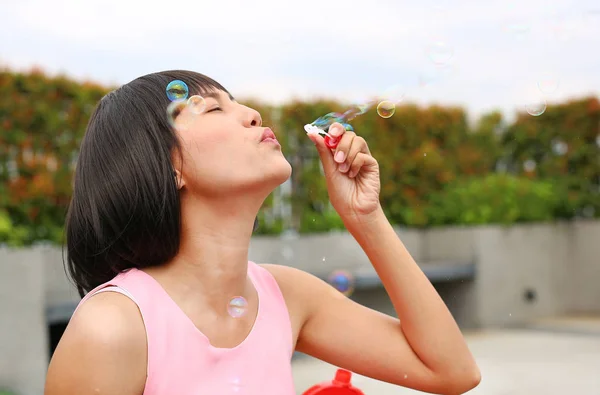 Joven asiático mujer jugando burbuja en la azotea de la construcción . —  Fotos de Stock