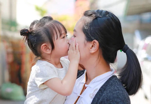 Gelukkig liefdevolle familie, moeder en kind meisje kussen. — Stockfoto