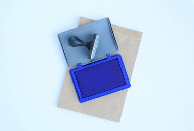 Beyaz arka plan kahverengi kitap lastik damgası ve mavi mürekkep kartuşları.