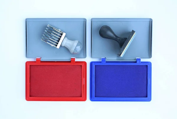 Sello de goma y cartuchos rojos de tinta azul sobre fondo blanco . —  Fotos de Stock