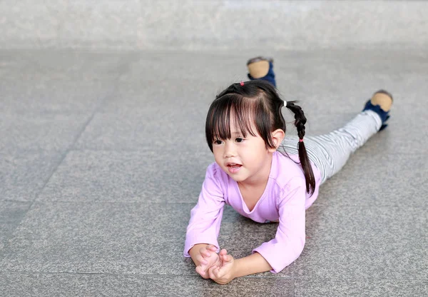 Portret szczęśliwy Ładna dziewczynka leżąc na podłodze korytarza — Zdjęcie stockowe