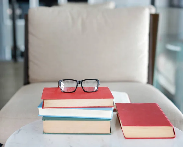 Pilha de livros didáticos na mesa com óculos no topo na sala da biblioteca, fundo conceito de educação . — Fotografia de Stock