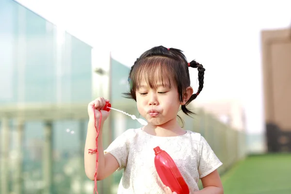 Retrato de niña encantadora soplando burbujas de jabón . — Foto de Stock