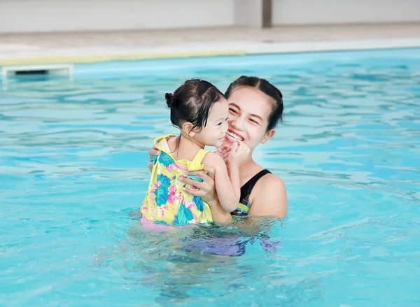 Закрыть мать, обучающую ребенка в бассейне — стоковое фото