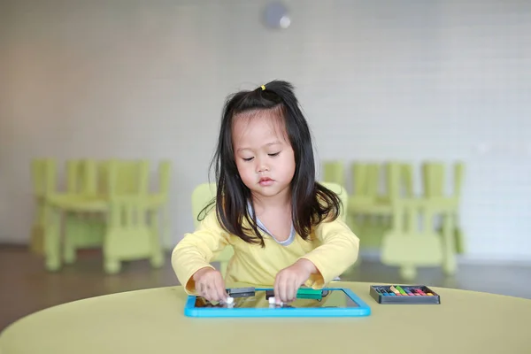 Petite asiatique enfant fille jouer craie sur tableau noir dans les enfants chambre . — Photo