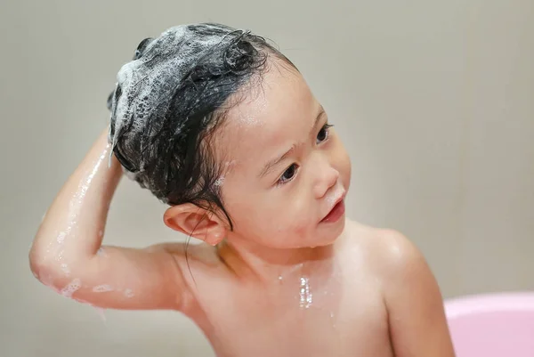 Söta lilla barn flicka tvätta håret i bubbelbad. — Stockfoto