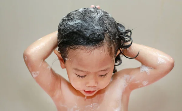 Liten flicka bad och tvätta håret i bubbelbad. — Stockfoto