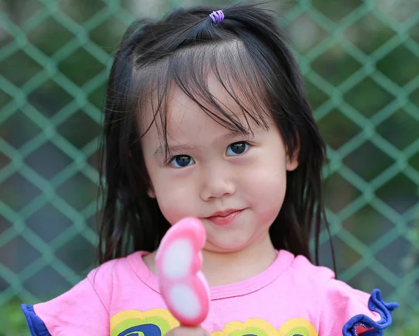 Menina pequena feliz comendo sorvete no parque — Fotografia de Stock