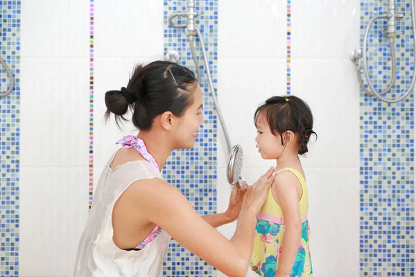 Ibu menuangkan air dari kamar mandi untuk anak-anak untuk menghangatkan tubuh sebelum berenang — Stok Foto