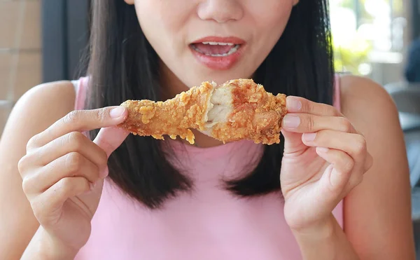 Närbild på ung asiatisk kvinna äta stekt kyckling i café. — Stockfoto