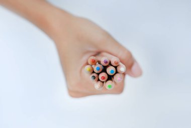 Üst el beyaz arka plan üzerinde renkli kalemler tutarak görüntülemek