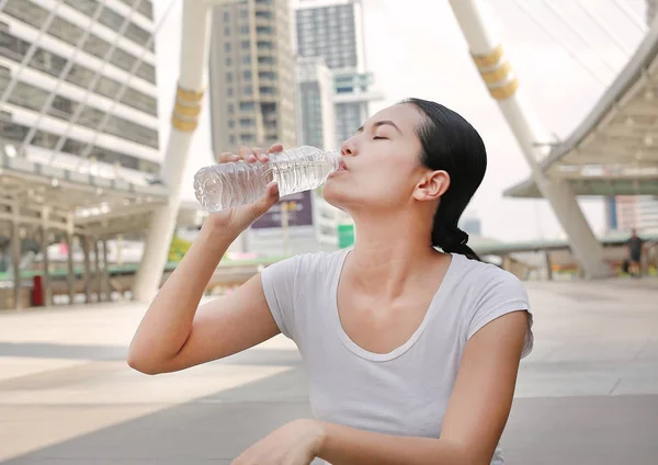 Femme eau potable dans la zone publique . — Photo