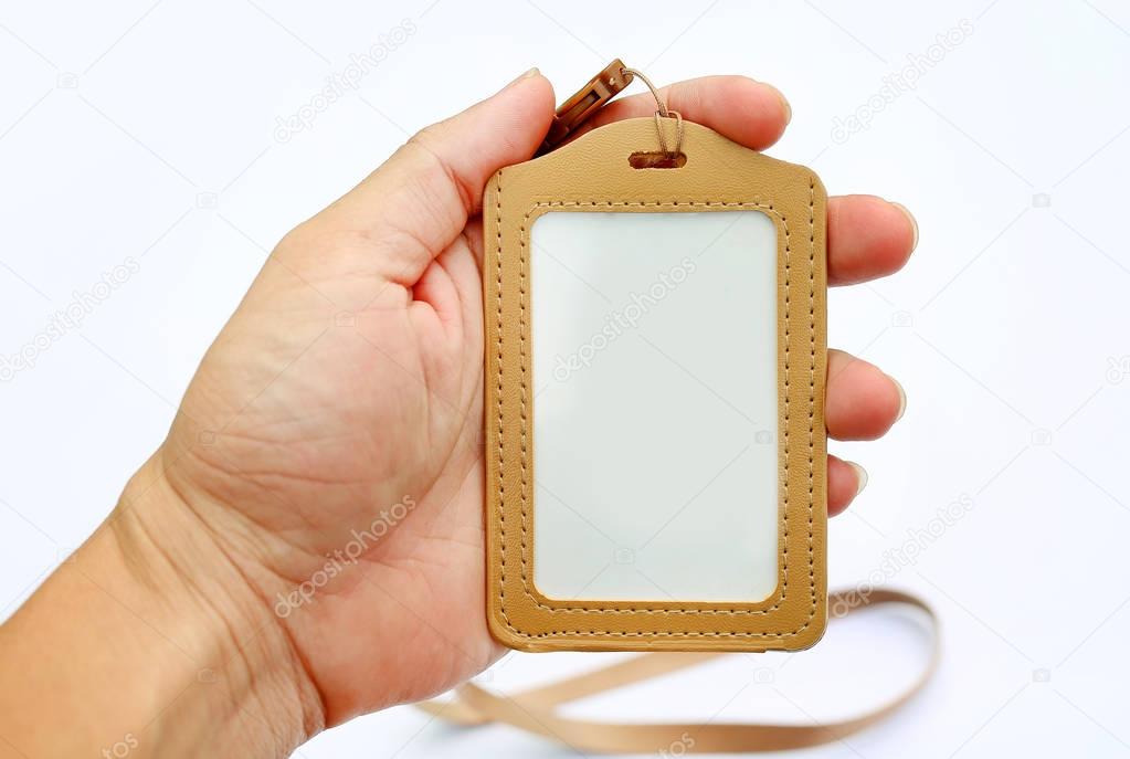 Hand holding blank badge cards and lanyards on white background