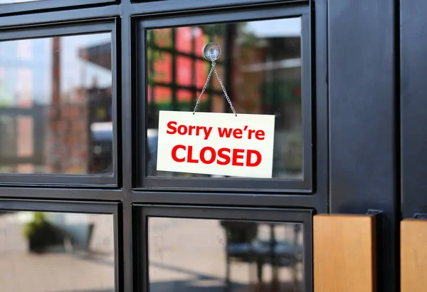 Sorry we're Closed teken boord opknoping op de deur van het café. — Stockfoto