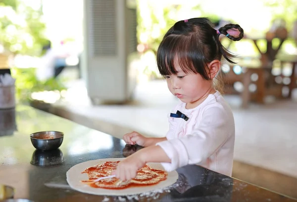Küçük Asyalı çocuk kız pizza yapma