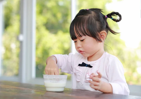 Pequeña chica asiática usando dedo comiendo helado casero en taza — Foto de Stock