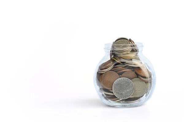International coins in a glass jar on white background with copy space. — Stock Photo, Image