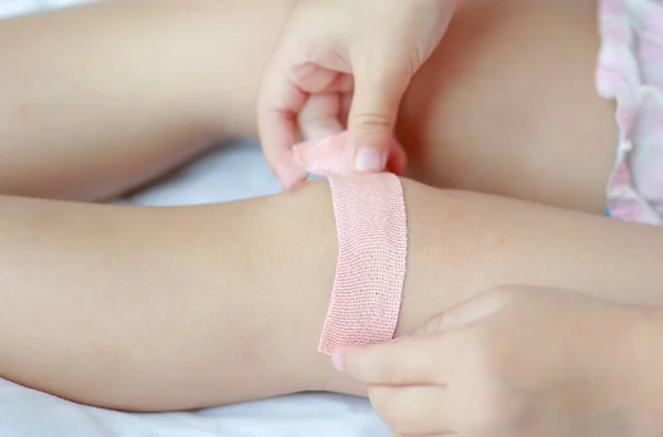 Close Up van kind knie met een pleister (van wonden), selectieve aandacht bij pleister. Gezondheidszorg en geneeskunde concept. — Stockfoto