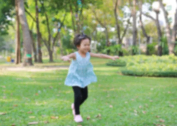 Imagem turva da menina criança feliz correndo no jardim — Fotografia de Stock