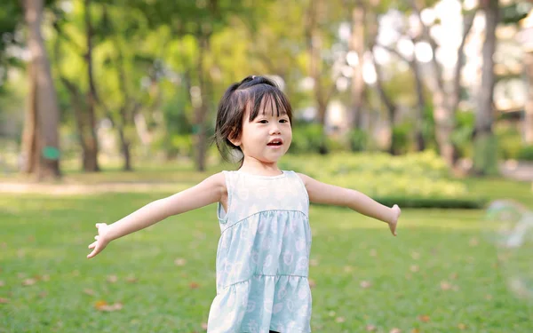 Söt liten flicka spela bubblan i trädgården. — Stockfoto
