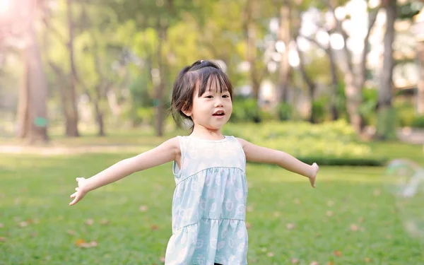 Niedliches kleines Mädchen spielt Blase im Garten. — Stockfoto