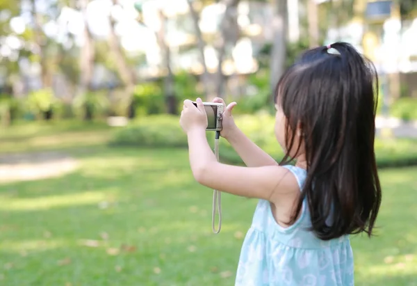 Mädchen fotografiert mit Kamera im Garten — Stockfoto