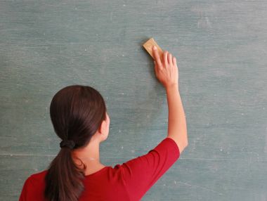 Asyalı öğretmen tahtaya kurulu silgi sınıf, eğitim kavramı siler.