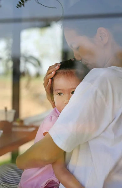 Gelukkig liefdevolle familie, moeder en kind meisje knuffelen in restaurant met reflectie — Stockfoto