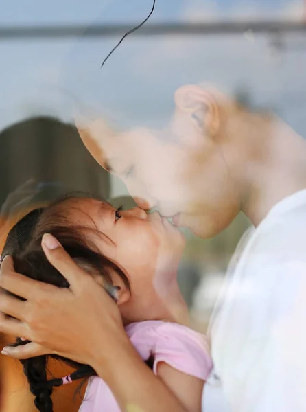 Happy loving family, mother and child girl kiss in restaurant with reflection — Stok Foto