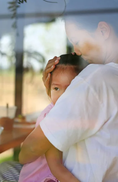 Happy loving family, mother and child girl hugging in restaurant with reflection