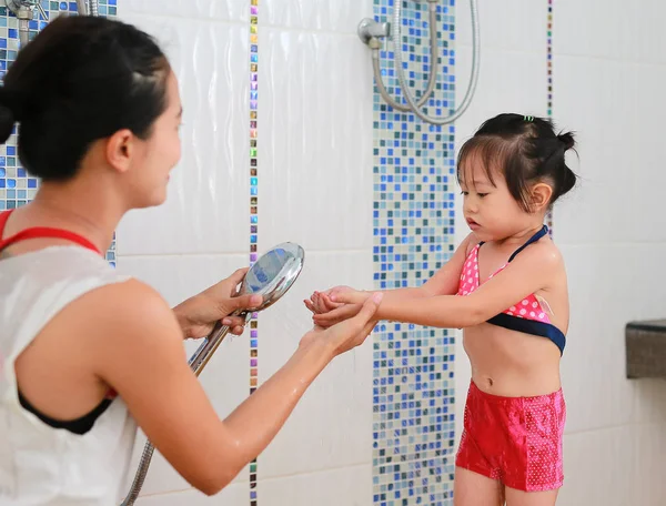Madre versa acqua dalla doccia per il bambino per riscaldare il corpo prima di nuotare — Foto Stock