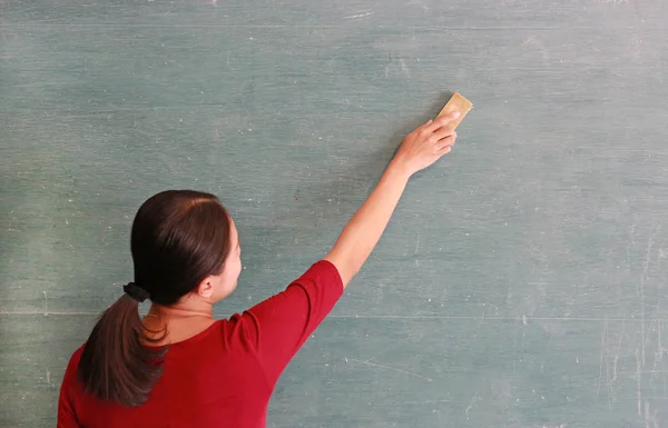 Ásia professor apaga no blackboard com bordo borracha em sala de aula, educação conceito . — Fotografia de Stock