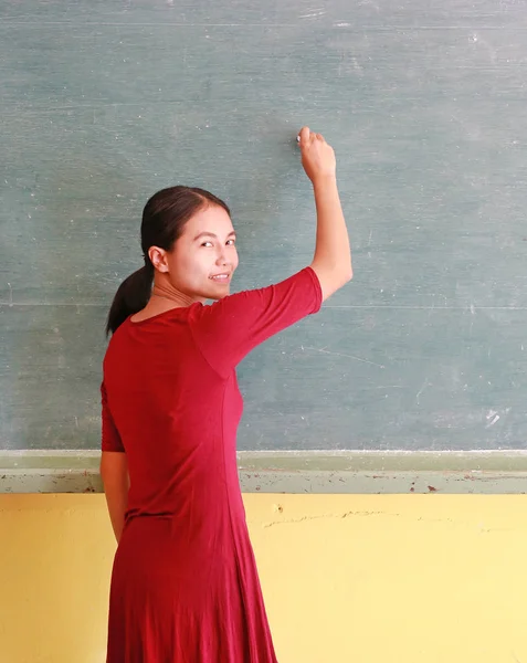 Ασιατικές δάσκαλος εγγράφως σχετικά με μαυροπίνακα με κιμωλία σε τάξη, εκπαιδευτικά έννοια. — Φωτογραφία Αρχείου