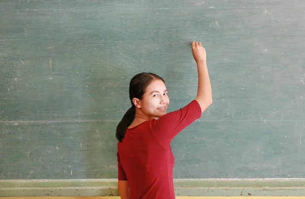 Ασιατικές δάσκαλος εγγράφως σχετικά με μαυροπίνακα με κιμωλία σε τάξη, εκπαιδευτικά έννοια. — Φωτογραφία Αρχείου