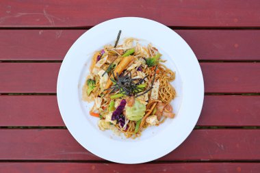 Üstten Görünüm Japon yakisoba erişte ahşap masa üzerinde beyaz plaka