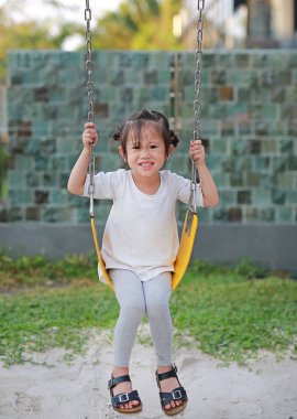 Parkta salıncağa oynayan çocuklar