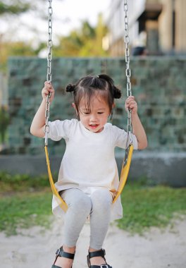 Parkta salıncağa oynayan çocuklar