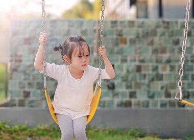 Parkta salıncağa oynayan çocuklar