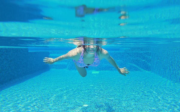 Foto subaquática de uma jovem mulher mergulhando na piscina . — Fotografia de Stock