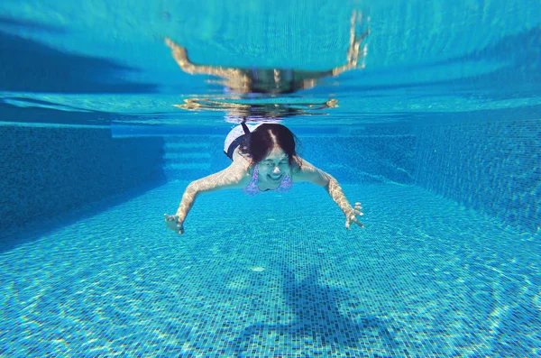 Foto subaquática de uma jovem mulher mergulhando na piscina . — Fotografia de Stock