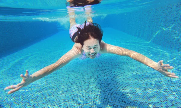 Plan sous-marin de jeune femme plongeant dans la piscine . — Photo