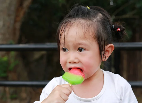 Petite fille mangeant de la glace dans le parc — Photo