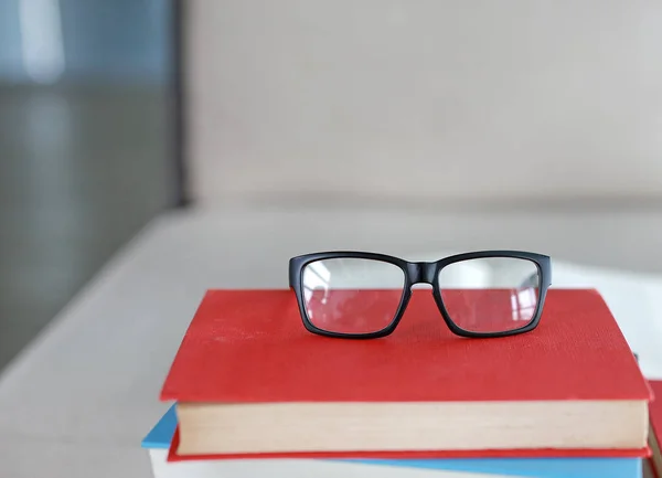 Куча учебников на столе с очками наверху в библиотечном зале, концепция образования . — стоковое фото