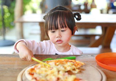 Küçük kız çocuk zevk pizza yemek.