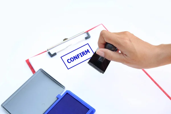 Közelről kezét bélyegzés megerősítése papírlap, kék tintával pad(box) fehér háttér. — Stock Fotó