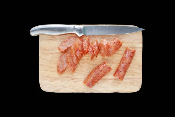 Нарізаний китайський ковбаски на рубки блоку з ножем, ізольовані на чорному фоні — стокове фото